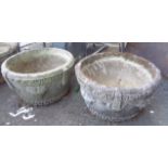 A pair of circular concrete garden planters with grapevine decoration