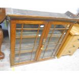 A 3' 2" early 20th Century stained oak bookcase top with lined shelves enclosed by a pair of