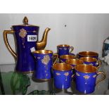 An Art Deco Carlton Ware six place coffee set with jewelled clusters on cobalt blue ground