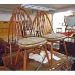 A set of four Ercol dark stained elm high hoop stick back kitchen chairs, set on simple turned