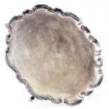 A 12 1/4" diameter silver salver with cast shaped rim and central engraved armourial featuring a