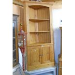 A 36" 20th Century waxed pine corner unit with three open shelves, canted corners and pair of