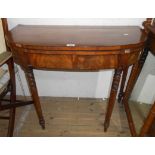 A 36" 19th Century demi-lune fold-over card table, set on ring turned legs - veneer and beading