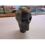 A brass walking stick top in the form of a skull