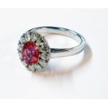 An unmarked high carat white metal ring, set with large central oval pink sapphire within a drop cut
