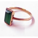 An unmarked high carat yellow metal ring, set oblong jade panel