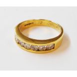 An import maked 750 gold ring, with seven chanel set brilliant cut diamonds