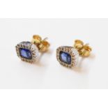 A pair of unmarked high carat white metal stud ear-rings, each set with central oblong sapphire