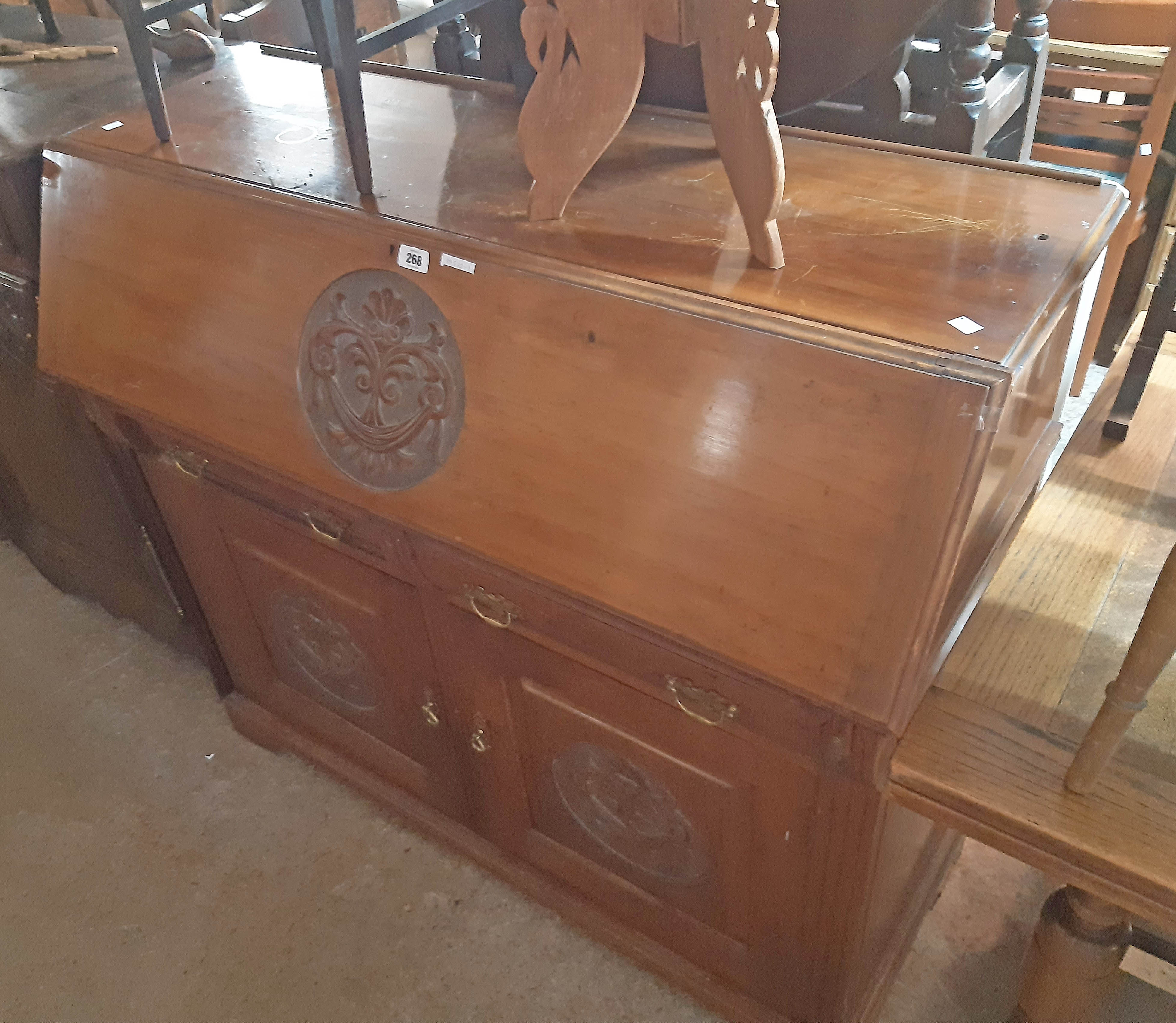 A 4' 19th Century walnut bureau base with carved roundel decoration and fitted interior over two