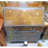 A 20th Century mahogany and stained wood bureau with part fitted interior, blind fretwork decoration
