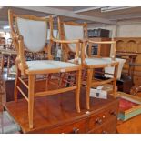 A pair of Edwardian inlaid mahogany shield back elbow chairs with upholstered backs and seats (one