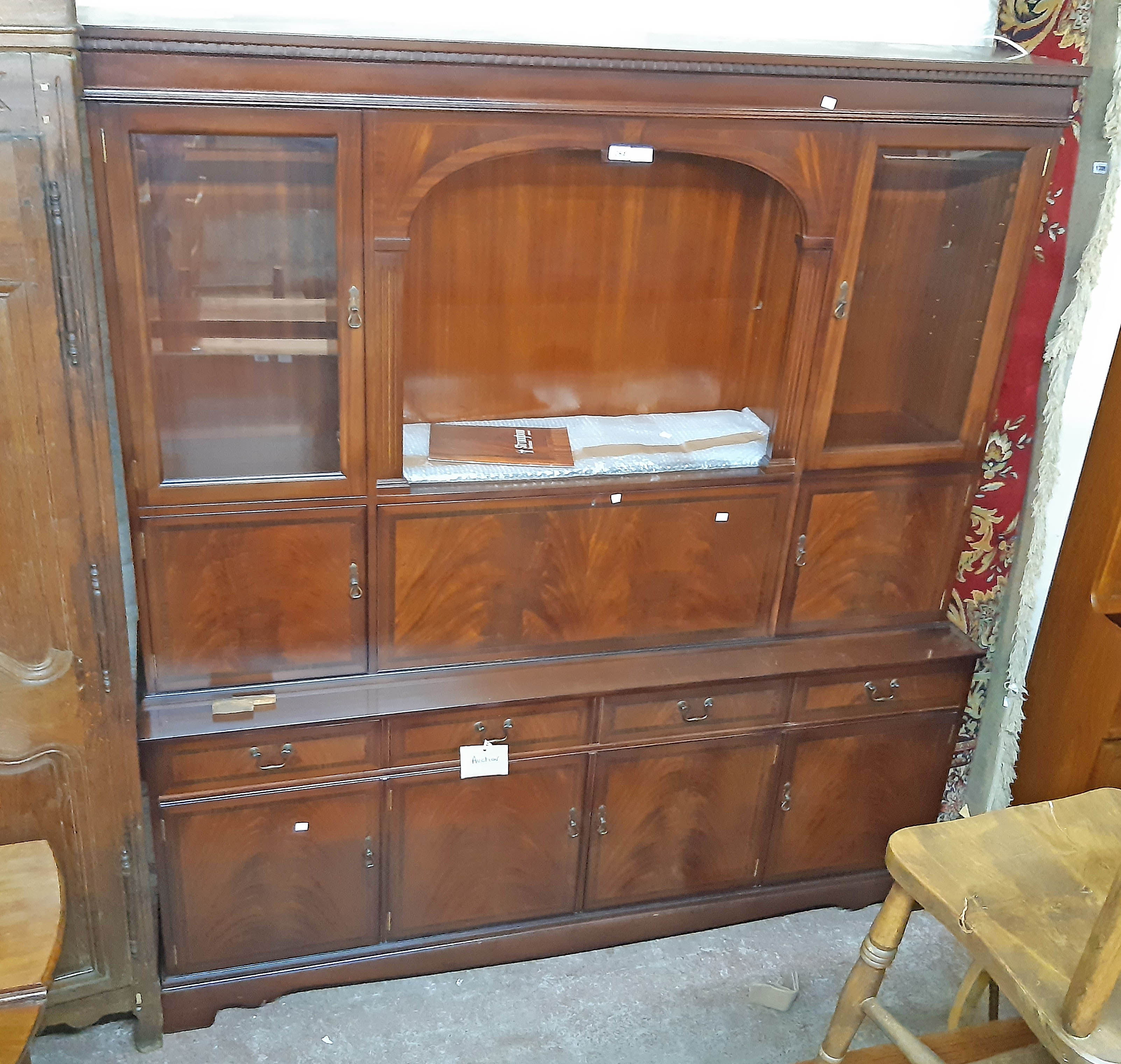 A 6' Stronbow Furniture reproduction mahogany two part wall unit with central arched recess,