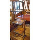 A 1930's mixed wood three tier folding cake stand with square surfaces and slender supports