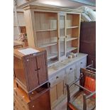 A 5' 11" waxed pine dresser base with three frieze drawers and flanking panelled cupboard doors