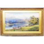 E Warrington: an ornate gilt framed and slipped watercolour, depicting cattle watering by a lake