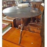 A 31" diameter late Georgian oak tilt-top table, set on turned pillar and tripod base - top split