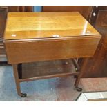 A vintage polished oak drop-leaf two tier tea trolley with flanking drawers