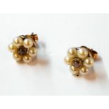 A pair of unmarked stud ear-rings, each set with central diamond within a six pearl border