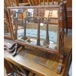 A late Victorian walnut framed swing dressing table mirror with oblong plate, set on turned supports