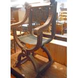 A 20th Century stained wood framed X-frame armourial elbow chair with carved applied lion mounts