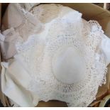 A bag containing assorted linen including lace edge tablecloths, pillow cases, table mats, etc.