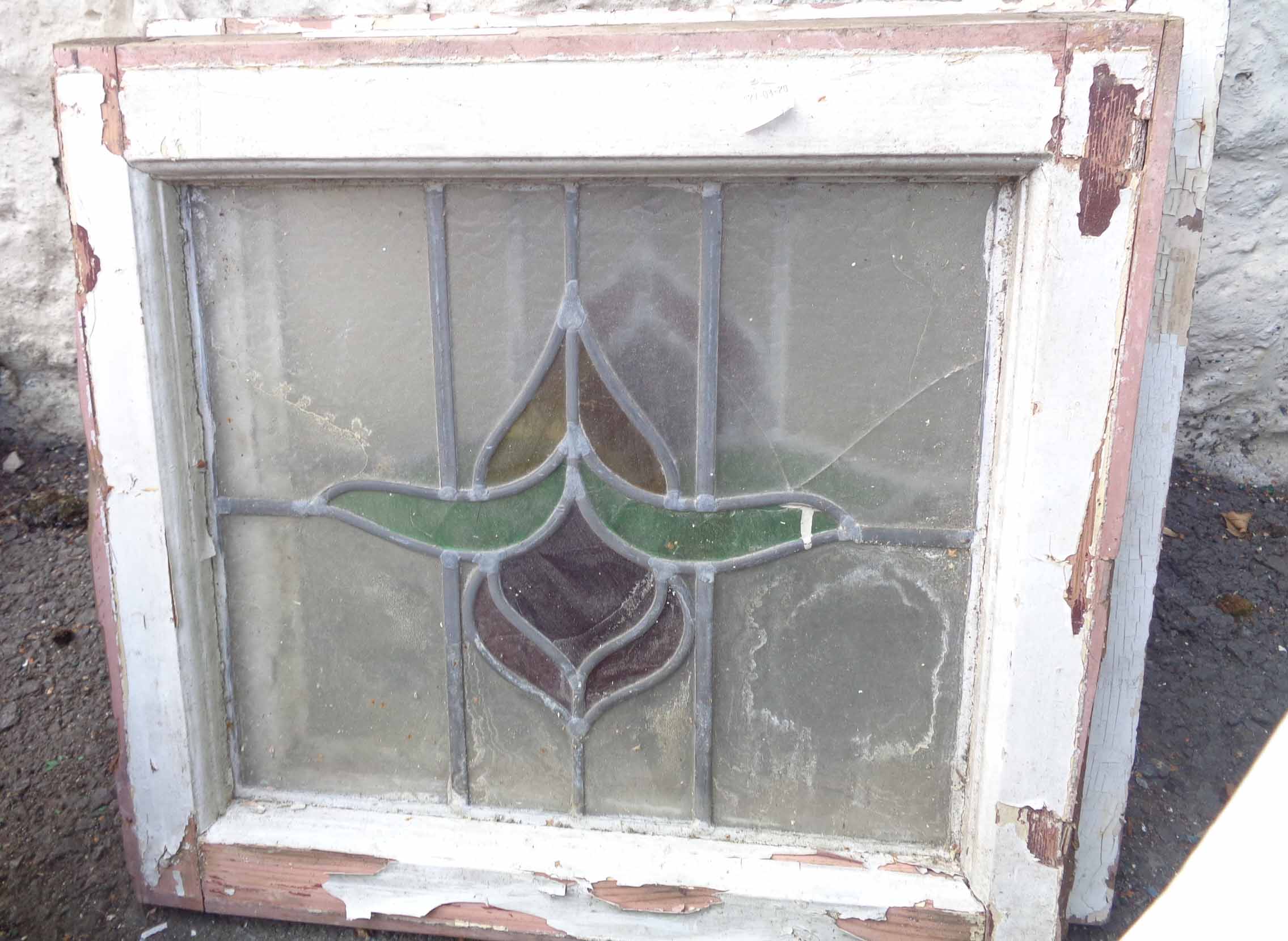 Two wooden framed stained glass windows with central stylized floral motif