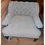 An old box framed nursing chair with studded upholstery, set on ebonised legs with Bakelite casters