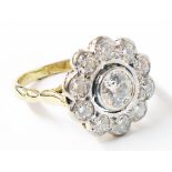 A marked 18ct flowerhead pattern ring, with central open collar set diamond within a ten stone