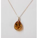 A marked 375 framed large citrine drop pendant with tiny diamond chips to border, on marked 9k