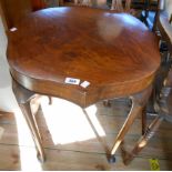 A 23 1/2" walnut quarter veneered serpentine topped occasional table, set on cabriole legs with