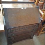 A 30" 20th Century oak bureau with part fitted interior and four drawers under, set on bracket