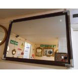 A campaign style modern stained wood framed oblong wall mirror with metal corners