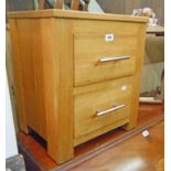 An 18 1/4" modern oak two drawer bedside chest, set on heavy block feet