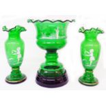 A Mary Gregory style garniture consisting of a green glass pedestal bowl sat on a black glass stand,