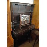 A 3' 8" Ercol dark stained elm two part dresser with two shelf open plate rack over a base with