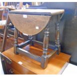 A 19 3/4" 20th Century oak swivel top drop-leaf tea table, set on a joint stool style stretcher