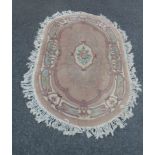 A Chinese oval washed wool rug