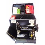 A vintage cased Singer Free-Arm Featherweight 222K sewing machine with booklet, accessories and