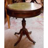 A 50cm diameter reproduction mahogany drum table with green leather inset top and two drawers, set