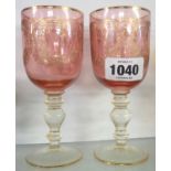 A pair of 20th Century cranberry glasses with etched and gilt decoration