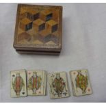 A small treen box with parquetry inlay to lid containing an old miniature deck of cards with