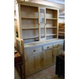A 1.8m waxed pine dresser base with three frieze drawers and flanking panelled cupboard doors under,