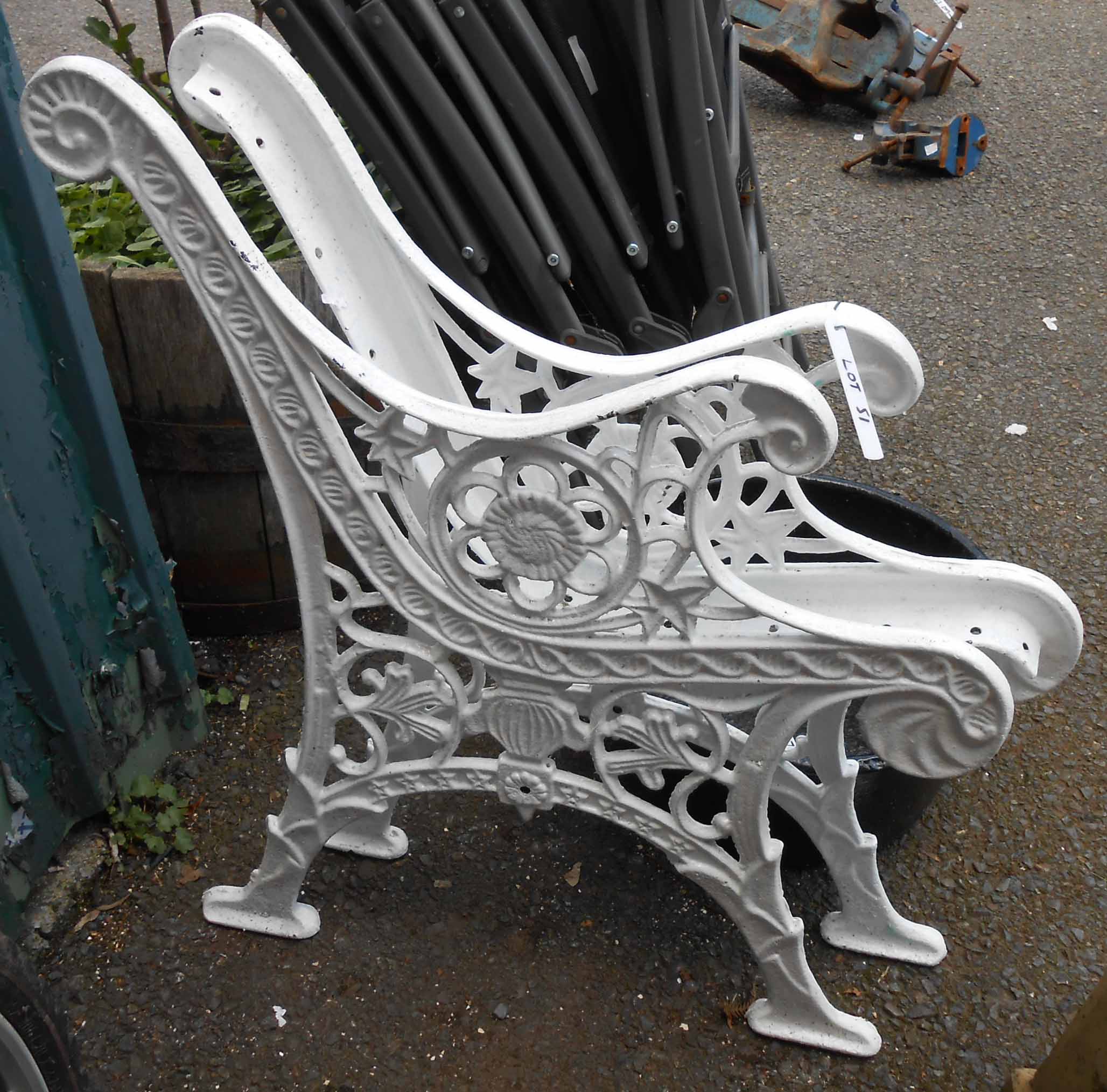 A pair of reproduction painted cast iron bench ends with decorative pierced decoration