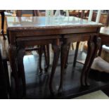 A reproduction quarter veneered figured walnut coffee table with glass inset top and two nesting tea