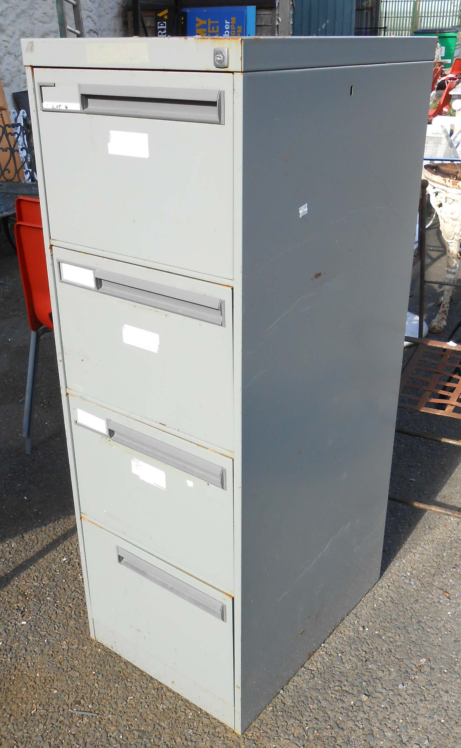 A grey painted metal four drawer filing cabinet