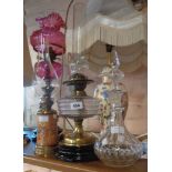 A Victorian table oil lamp with clear glass reservoir and original chimney - sold with another