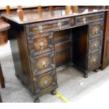 A 92cm early 20th Century stained oak knee-hole desk with two frieze drawers, central cupboard and