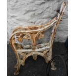 A pair of old painted cast iron bench ends with vine leaf decoration