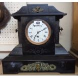 A large late Victorian black slate and decorative cast metal mounted mantle timepiece of