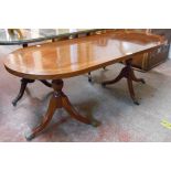 A 1.21m reproduction mahogany and strung twin pedestal coffee table, set on tripod bases with